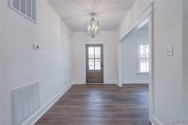 foyer entrance with visible vents, a healthy amount of sunlight, and dark wood finished floors