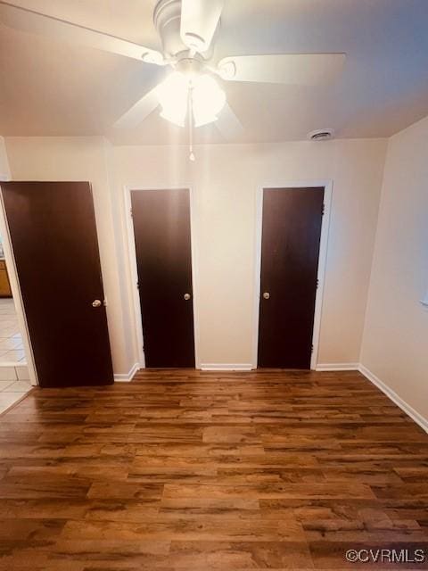 unfurnished bedroom featuring wood finished floors, baseboards, and ceiling fan