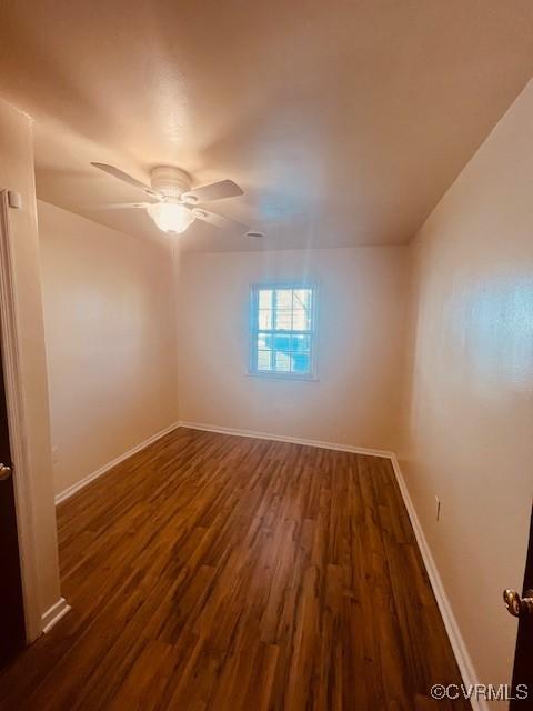 unfurnished room with dark wood-style floors, baseboards, and ceiling fan