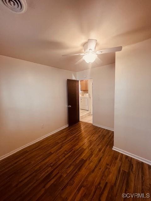 unfurnished room featuring dark wood finished floors, visible vents, a ceiling fan, and baseboards