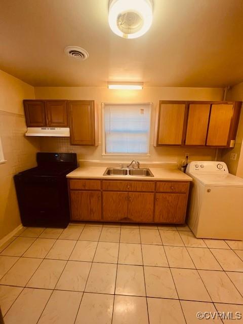 kitchen with light tile patterned floors, washer / clothes dryer, a sink, stove, and under cabinet range hood