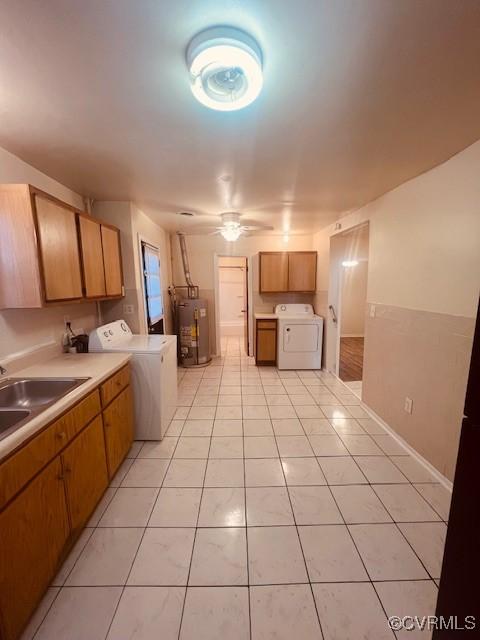 kitchen with ceiling fan, light countertops, water heater, light tile patterned flooring, and a sink