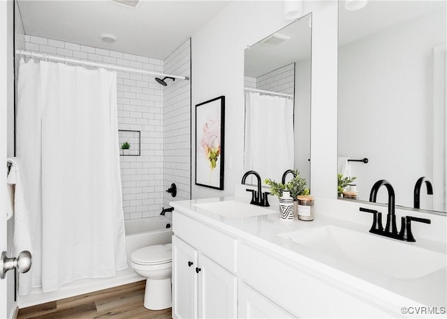 bathroom with double vanity, wood finished floors, shower / tub combo with curtain, and a sink