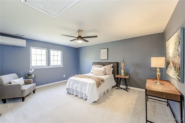 bedroom with baseboards, ceiling fan, attic access, a wall unit AC, and light carpet