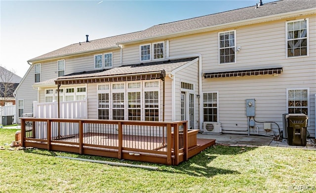 back of property with central AC unit, a wooden deck, a yard, and ac unit