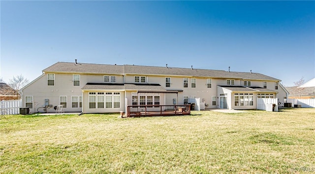 rear view of house featuring a deck, a patio area, fence, and a lawn