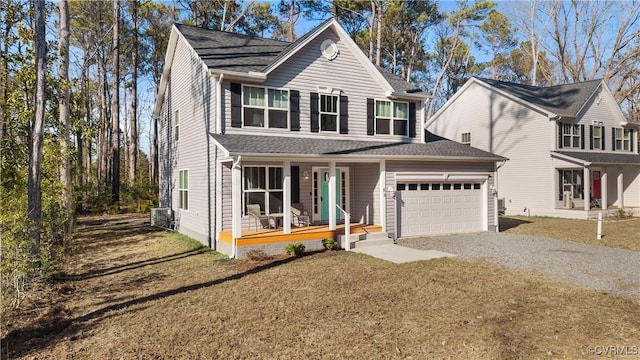 traditional home with gravel driveway, covered porch, a front yard, a shingled roof, and a garage