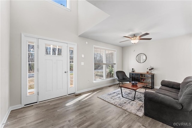 entryway with ceiling fan, visible vents, baseboards, and wood finished floors