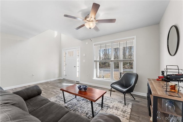 living area with vaulted ceiling, ceiling fan, baseboards, and wood finished floors