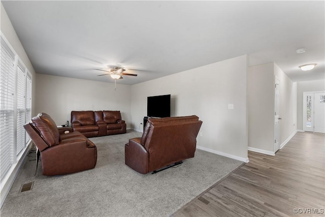 living area featuring ceiling fan, wood finished floors, visible vents, and baseboards