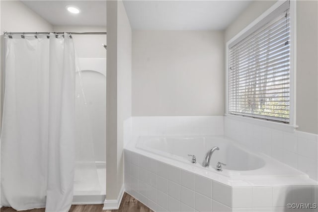 full bathroom featuring wood finished floors, a shower with curtain, and a bath