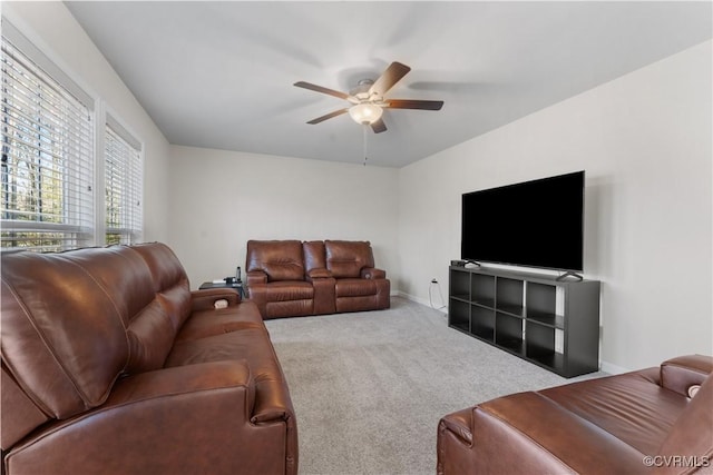 carpeted living room featuring baseboards and ceiling fan