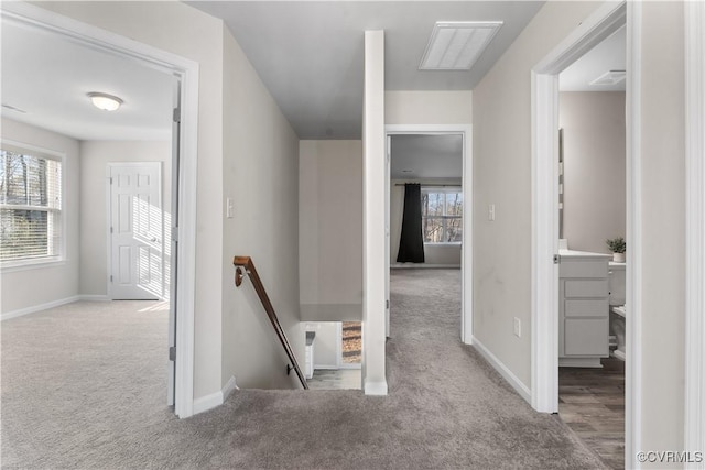 hall featuring an upstairs landing, carpet flooring, plenty of natural light, and visible vents