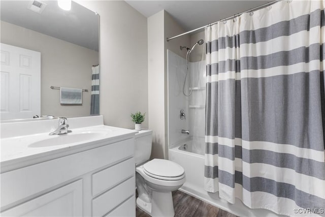 bathroom with visible vents, toilet, shower / tub combo, wood finished floors, and vanity