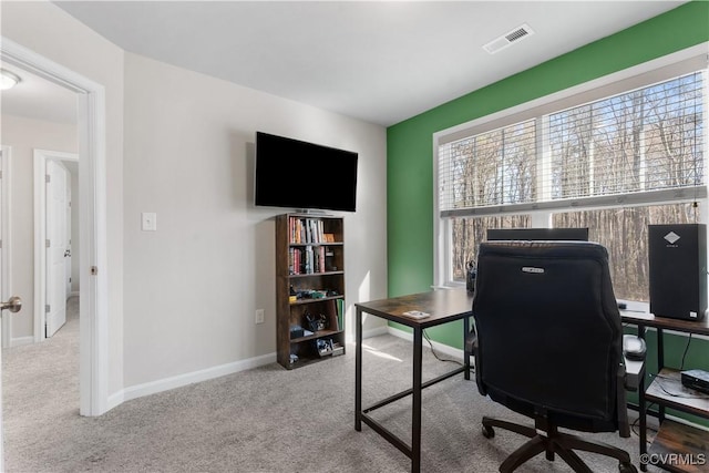 carpeted office space featuring visible vents and baseboards