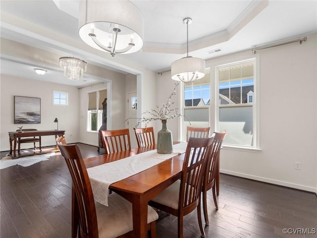 dining space featuring visible vents, ornamental molding, dark wood finished floors, baseboards, and a raised ceiling