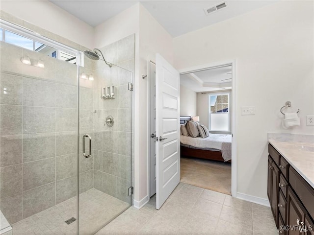 ensuite bathroom featuring visible vents, a stall shower, ensuite bathroom, vanity, and a raised ceiling