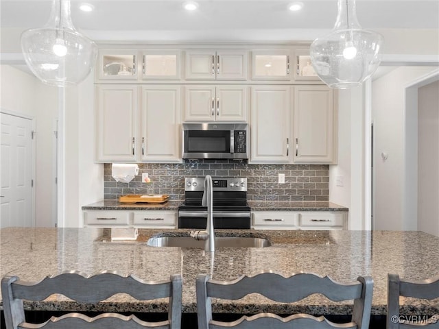 kitchen with dark stone countertops, a kitchen breakfast bar, and stainless steel appliances