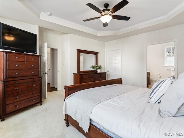 bedroom with visible vents, light carpet, ensuite bathroom, crown molding, and a raised ceiling