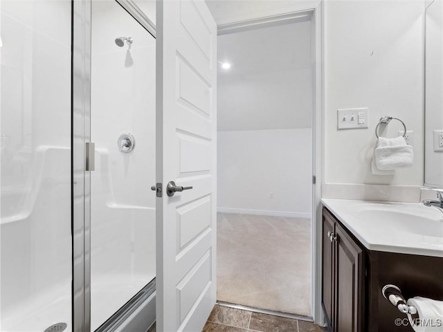 bathroom with a shower stall, vanity, lofted ceiling, and baseboards