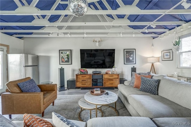 living room with beam ceiling, wood finished floors, and track lighting