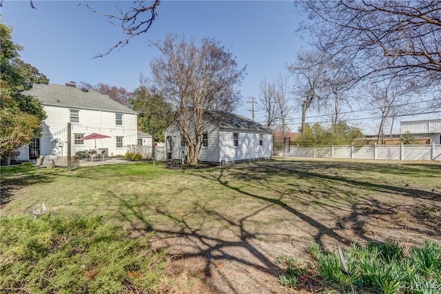 view of yard with a patio, an outdoor structure, and fence