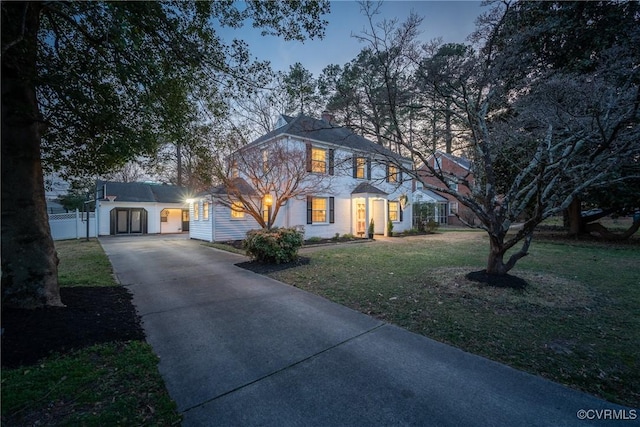 view of front of house with a front lawn, fence, and driveway