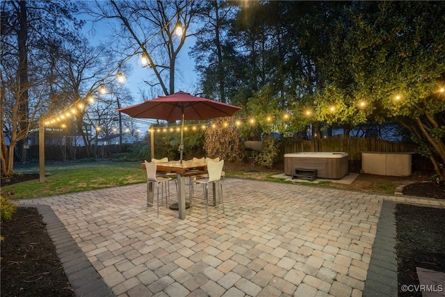 view of patio / terrace featuring outdoor dining space, a hot tub, and a fenced backyard