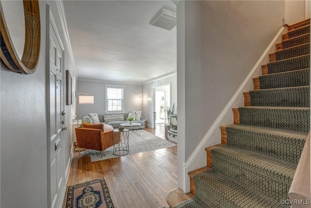 interior space with crown molding, baseboards, and hardwood / wood-style flooring