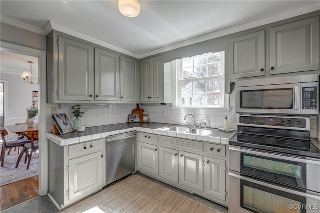 kitchen with tasteful backsplash, tile countertops, stainless steel appliances, and a sink