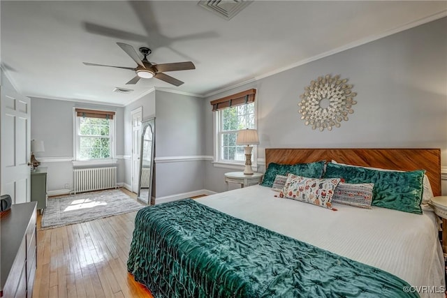 bedroom with visible vents, multiple windows, radiator, and light wood-style flooring