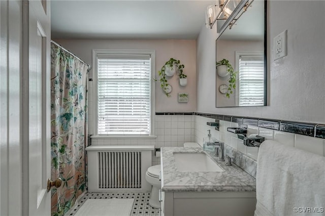 bathroom with curtained shower, radiator, toilet, and vanity