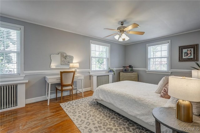 bedroom featuring multiple windows, crown molding, and wood finished floors