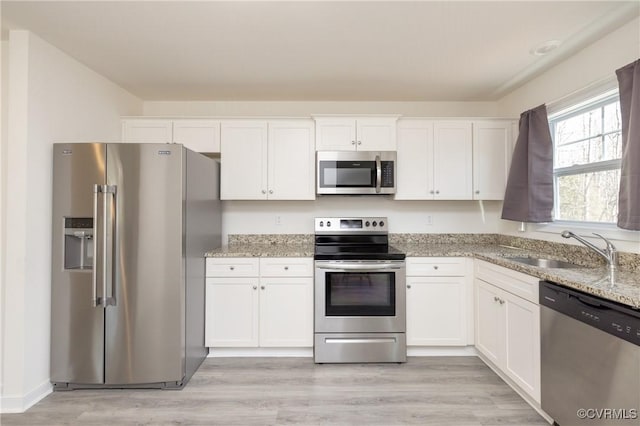 kitchen with white cabinets, appliances with stainless steel finishes, and a sink