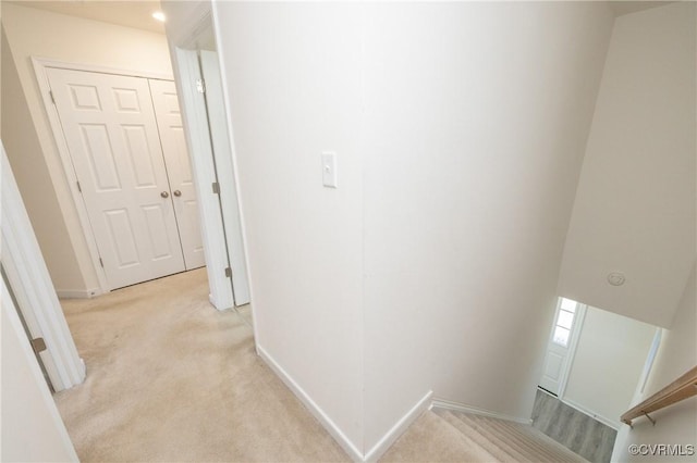 hall with light colored carpet and baseboards