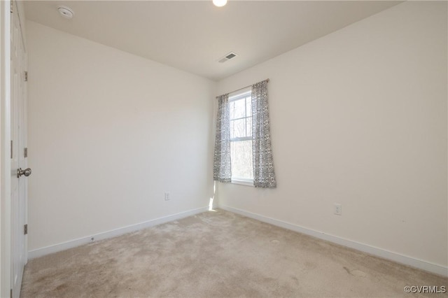 unfurnished room featuring visible vents, light carpet, and baseboards