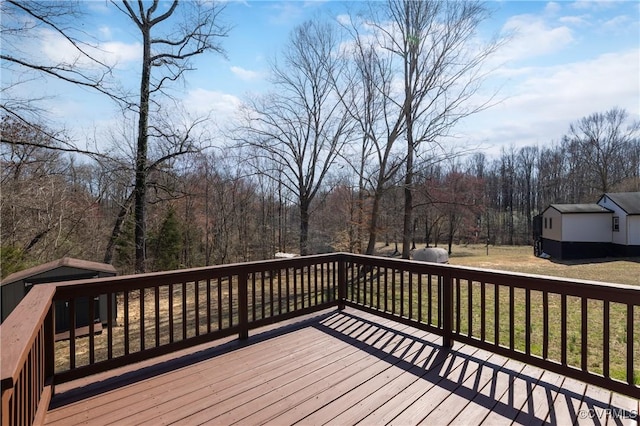 wooden terrace with a yard and an outdoor structure