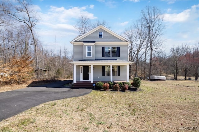 view of front of house featuring aphalt driveway, covered porch, and a front lawn