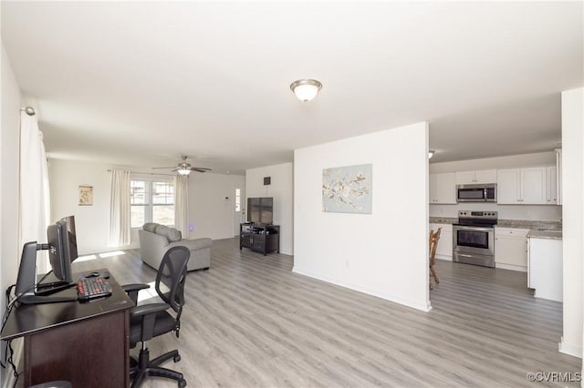 home office featuring ceiling fan, baseboards, and light wood-style floors