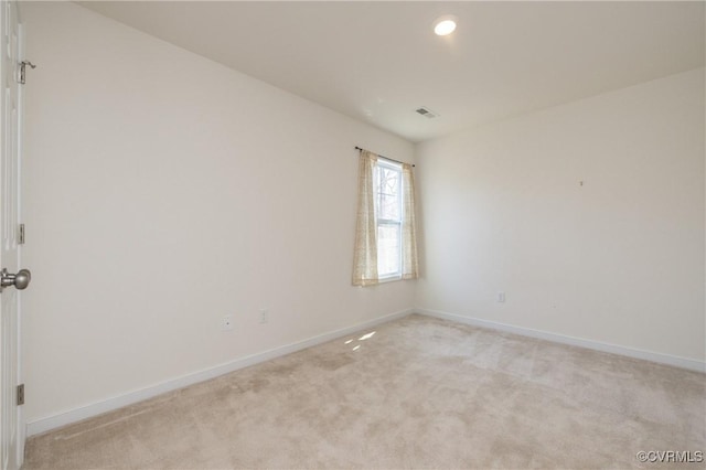 empty room with recessed lighting, light colored carpet, visible vents, and baseboards