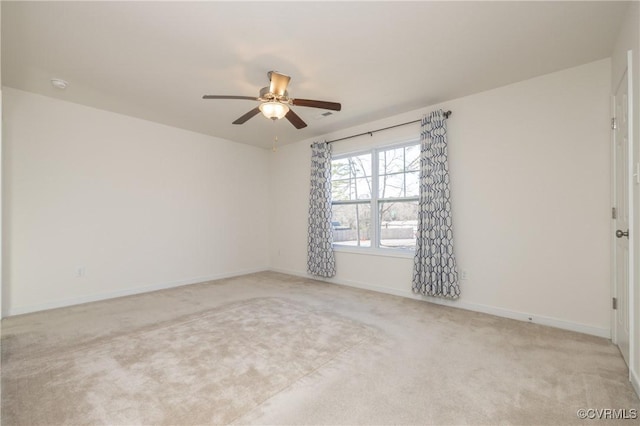 spare room featuring carpet flooring, baseboards, and ceiling fan