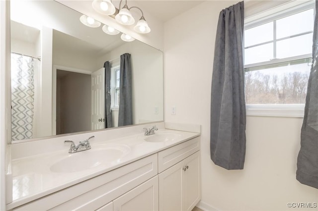 full bathroom featuring double vanity, a chandelier, and a sink