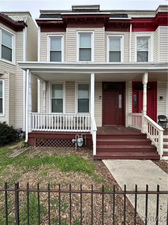 view of property with a fenced front yard and covered porch