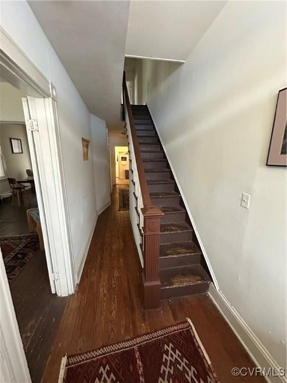 staircase with wood finished floors and baseboards