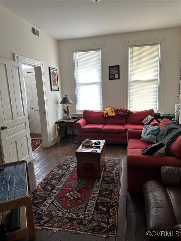 living area with wood finished floors and visible vents