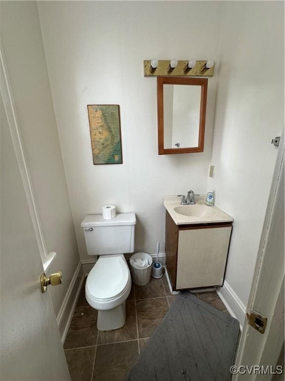 bathroom with tile patterned flooring, toilet, vanity, and baseboards