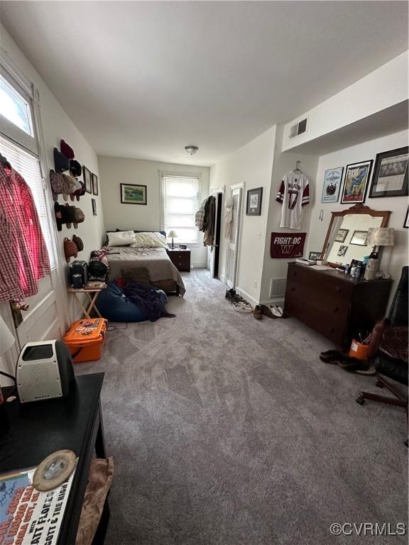 bedroom featuring visible vents, baseboards, and carpet