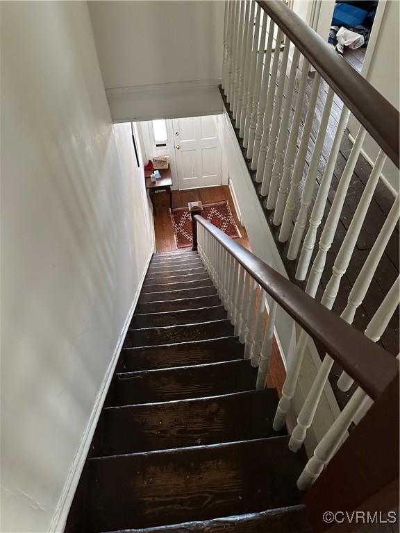 stairway featuring baseboards and wood finished floors