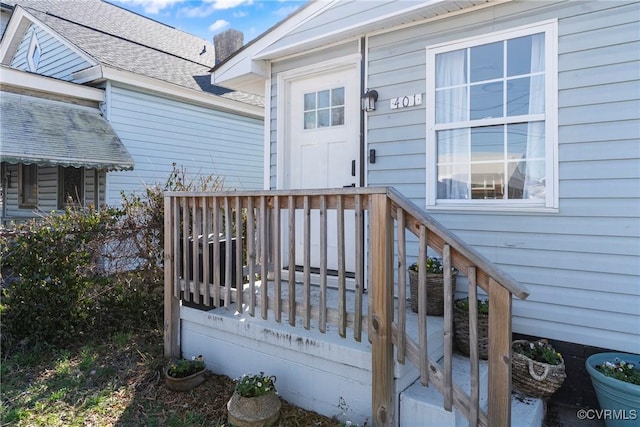 doorway to property featuring a shingled roof