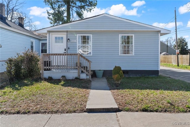 view of front facade featuring a front lawn and fence